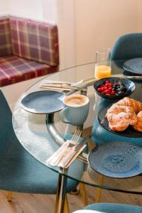 a glass table with plates of food on it at 3 Bed Traditional Apartment on Picturesque Victoria St in Edinburgh