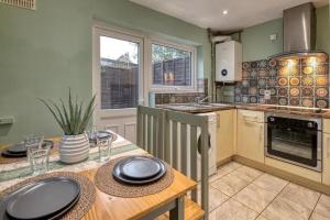 a kitchen with a wooden table with plates on it at Stylish 2BR Cottage Pet-Friendly with Free Parking in Partington