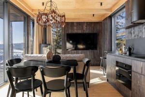 a dining room with a black table and chairs at Mountain air Horishnii in Palyanytsya