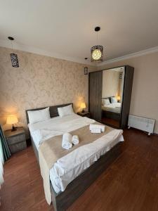 een slaapkamer met een groot bed met handdoeken erop bij Prestige Tower Batumi in Itʼkhvisi +42 foto's