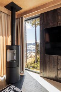 a fireplace in a room with a tv and a window at Mountain air Horishnii in Palyanytsya