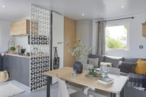 a kitchen and a living room with a dining room table at Le Beaupré - prestation hotelière in Mesquer