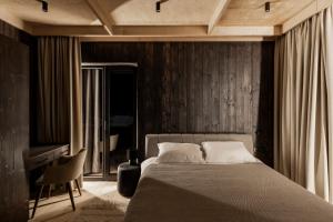 a bedroom with a large bed and a chair at Mountain air Horishnii in Palyanytsya