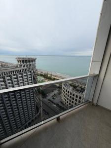 een balkon met uitzicht op de oceaan en gebouwen bij Prestige Tower Batumi in Itʼkhvisi