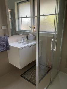 een badkamer met een wastafel en een glazen douche bij Frankston Vacation Home in Frankston East +24 foto's