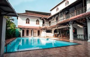 a swimming pool in the courtyard of a house at The Heritage By Boho Travelista in Cochin