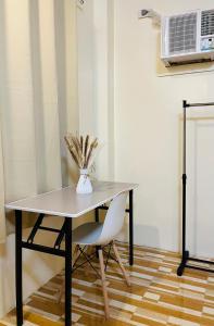 a table and a chair with a vase of flowers at Ambungan Homestay - Siargao in General Luna +9 photos