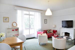 a living room with a red couch and a fireplace at SPACIOUS Apartment in London