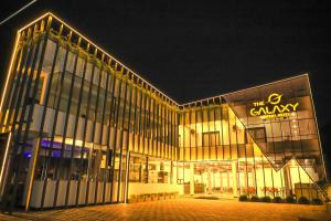 a large building with a sign on it at night at The Galaxy Airport Hotel in Negombo