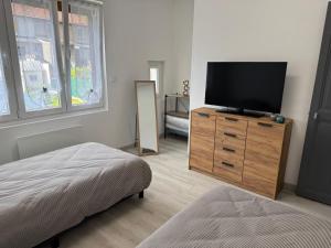 - une chambre avec une télévision sur une commode en bois dans l'établissement Gîte des Prés, à Revin