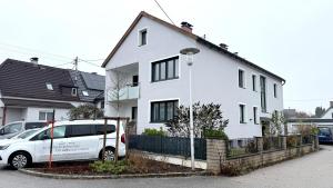 a white car parked in front of a white house at Easyapartments Leo in Linz