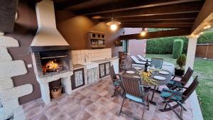 Un patio con chimenea y una mesa y sillas. en Chalet Rural Toñita 400 m playa piscina barbacoa chimenea, en Bueu