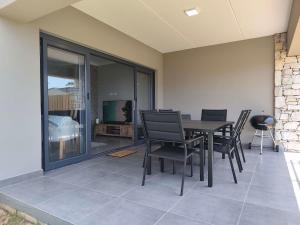 een eetkamer met een tafel en stoelen bij Langdown Loft - Central 3BD Townhouse in Plettenbergbaai