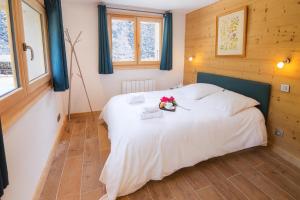 een slaapkamer met een wit bed met bloemen erop bij Appartement La Creusettaz Happy Rentals in Chamonix-Mont-Blanc