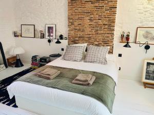 ルゼにあるSolar - Maison de pêcheurのレンガの壁、ベッド1台、