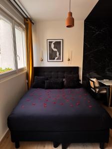 une chambre avec un lit orné de fleurs rouges dans l'établissement Jacuzzi privé, Sauna & Design Chic, à Reims