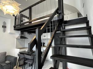 a black spiral staircase in a living room at NEKTAR home in Latsídha