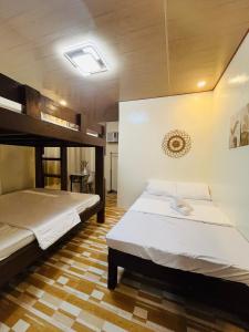two beds in a large room with at Ambungan Homestay - Siargao in General Luna