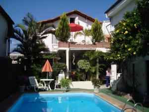 a swimming pool in front of a house at Chale Mineiro Hostel & Pousada in Belo Horizonte