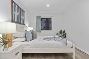 een witte slaapkamer met een bed en een raam bij Cityscape on Mounts Bay in Perth