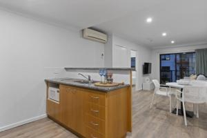 een keuken met een wastafel en een eetkamer met een tafel bij Cityscape on Mounts Bay in Perth