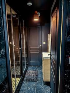 un couloir avec une porte bleue et un lavabo dans l'établissement Jacuzzi privé, Sauna & Design Chic, à Reims