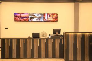 ネゴンボにあるThe Galaxy Airport Hotelの受付デスクと壁に絵が飾られたオフィス