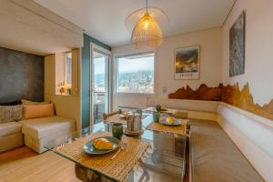 una sala de estar con un sofá y una mesa en Le Balcon du Brévent - Happy Rentals, en Chamonix-Mont-Blanc