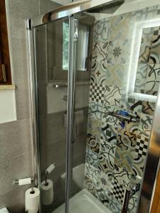 une douche avec une porte en verre dans une salle de bain dans l'établissement la casa sull'arcobaleno 1, à Manta