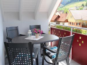 una mesa y sillas en un balcón con vistas en Ferienwohnungen Beilerstädtle, en Oppenau