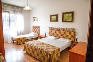 a hotel room with two beds and a window at Downtown flat 250mt from the beach in Eraclea Mare