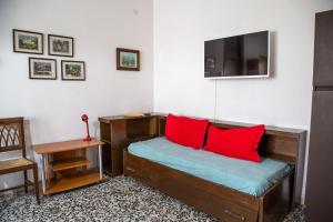 1 dormitorio con cama con almohadas rojas y escritorio en Downtown flat 250mt from the beach, en Eraclea Mare
