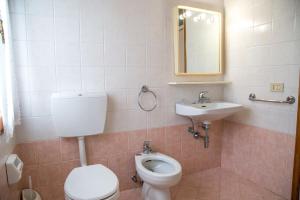 un baño con inodoro y lavabo en Downtown flat 250mt from the beach, en Eraclea Mare 18 fotos más