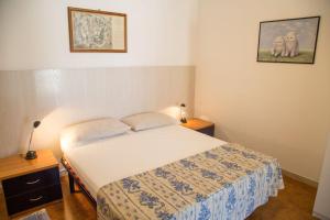 um pequeno quarto com uma cama e duas mesas de cabeceira em Centric apartment by the beach em Eraclea Mare