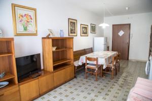 uma sala de estar com uma mesa e uma televisão em Centric apartment by the beach em Eraclea Mare