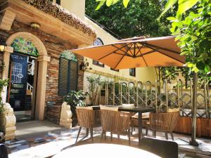 een tafel en stoelen met een parasol op een terras bij Half-City Homestay in Xi'an