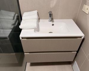 ein Badezimmer mit einem weißen Waschbecken und Handtüchern in der Unterkunft Зелено Східниця in Schidnyzja + 7 Fotos