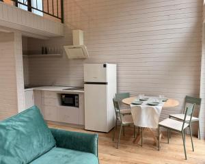 ein Wohnzimmer mit einem Tisch und einem Kühlschrank in der Unterkunft Зелено Східниця in Schidnyzja