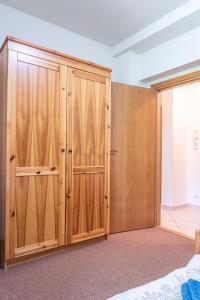a bedroom with wooden cabinets and a closet at Lomnica Orange Apart in Tatranská Lomnica