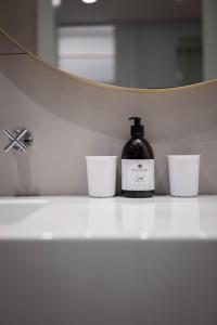 ミュンヘンにあるJugend- und Familienhotel Augustinの2つの白いカップの隣に置かれた石鹸のボトル +57枚の写真