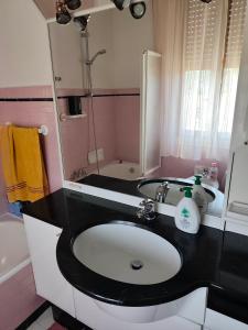 a bathroom with a black and white sink and a mirror at Casa Natale in Prato Sesia +26 photos