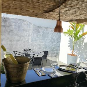 uma mesa com uma garrafa de vinho e copos em Acolhedora casa de 03 quartos em Passos