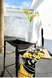 uma churrasqueira com uma mesa com uma manta e uma faca em Acolhedora casa de 03 quartos em Passos