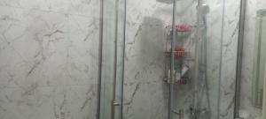 a shower with a glass door in a bathroom at Gusar Apartment in Qusar +12 photos