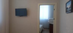 a room with a tv on the wall of a bathroom at Gusar Apartment in Qusar