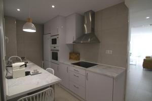 Una cocina con gabinetes blancos y encimera. en Alameda 16 Apartment Beach Old Town, en Benidorm