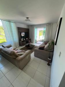 ein Wohnzimmer mit zwei Sofas und einem Fernseher in der Unterkunft Refúgio dos Pássaros in Campo Largo