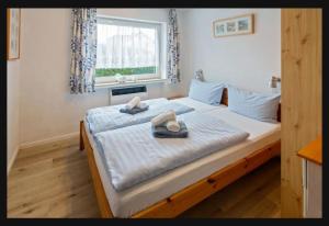 a bedroom with a large bed with towels on it at Ferienwohnung Seesternchen am Deich2 C46 in Norden