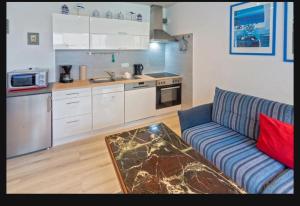 a living room with a couch and a kitchen at Ferienwohnung Seesternchen am Deich2 C46 in Norden +7 photos