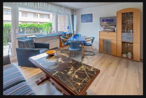 a living room with a table and a kitchen at Ferienwohnung Seesternchen am Deich2 C46 in Norden